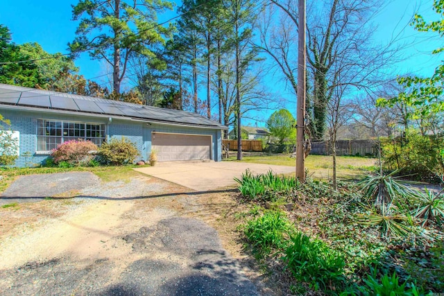 3110 Edison Ave, Benton, AR 72015 - view of home's exterior featuring roof mounted solar panels, brick siding, a garage, and concrete driveway