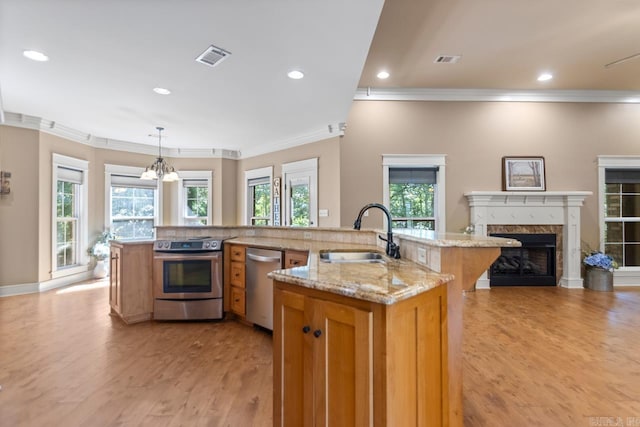 5611 Pear Tree Dr, Little Rock, AR 72206 - kitchen with appliances with stainless steel finishes, a sink, crown molding, light wood finished floors, and a kitchen island with sink