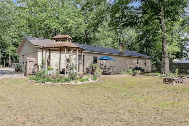 234 Robin Ln, Walnut Ridge, AR 72476 - rear view of house with a gazebo, a chimney, brick siding, and view of wooded area