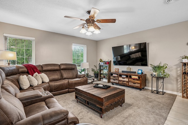 living room with ceiling fan, light tile patterned floors, and baseboards