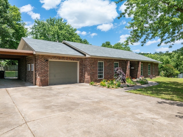 single story home with brick siding, an attached garage, concrete driveway, a front lawn, and a carport
