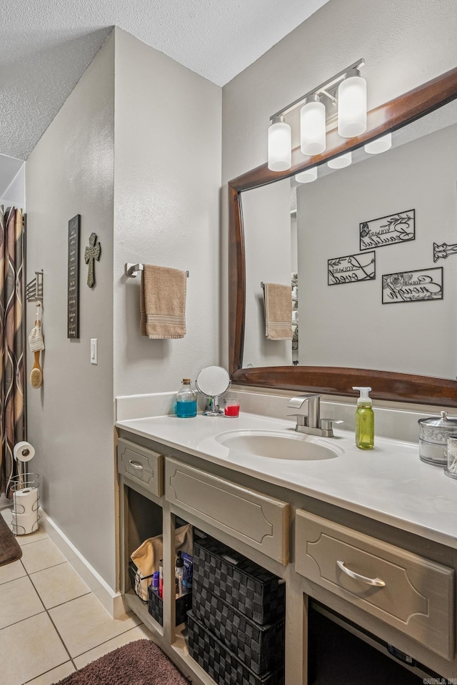 bathroom with a textured ceiling, vanity, and tile patterned flooring
