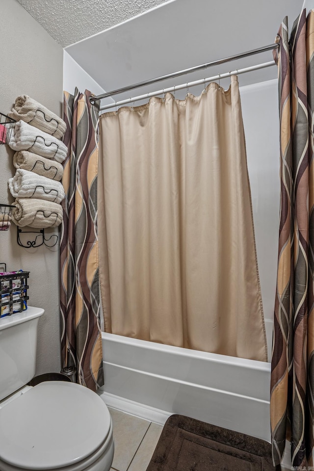 full bathroom with shower / tub combo with curtain, toilet, tile patterned floors, and a textured ceiling
