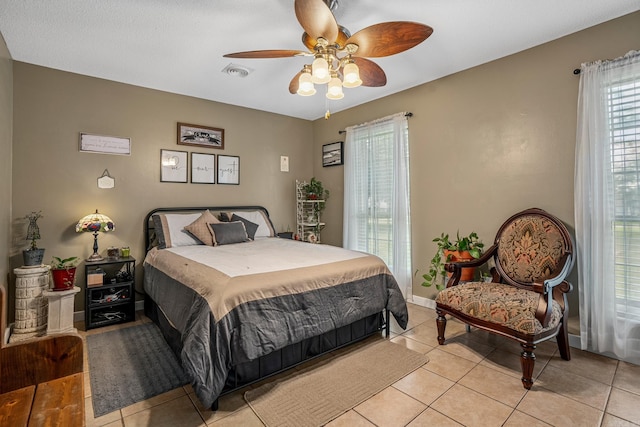 bedroom featuring light tile patterned floors, a ceiling fan, and baseboards