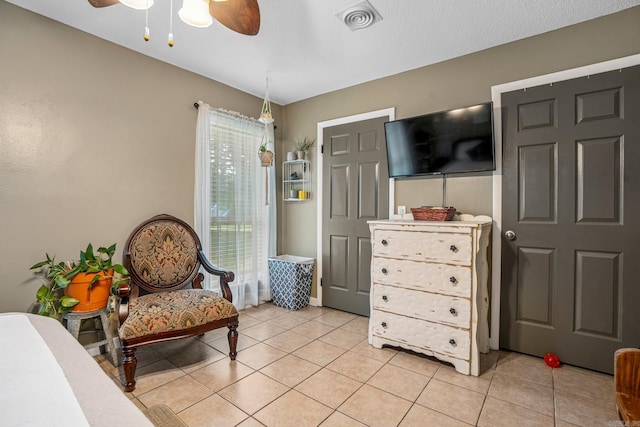 living area featuring ceiling fan and light tile patterned flooring