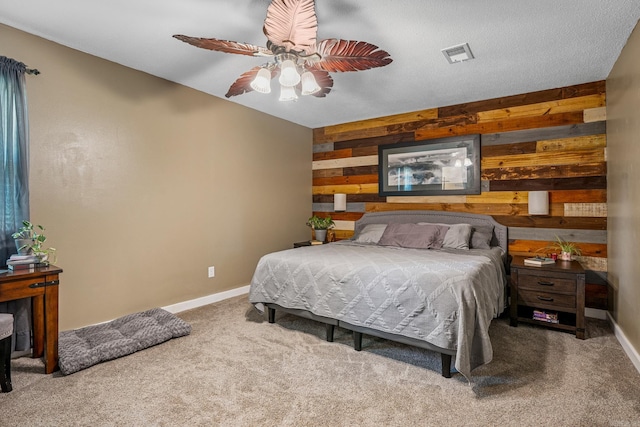 bedroom featuring wooden walls, baseboards, carpet floors, and a ceiling fan