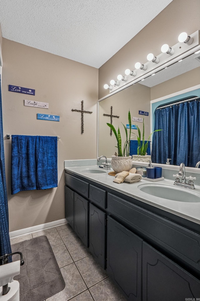 bathroom with double vanity, tile patterned floors, and a textured ceiling