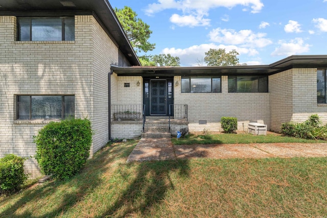 6500 W 12th St, Little Rock, AR 72204 - view of front of home featuring brick siding, crawl space, and a front lawn