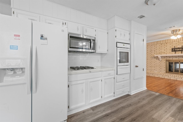 6500 W 12th St, Little Rock, AR 72204 - kitchen with white appliances, a warming drawer, white cabinetry, ceiling fan, and tasteful backsplash