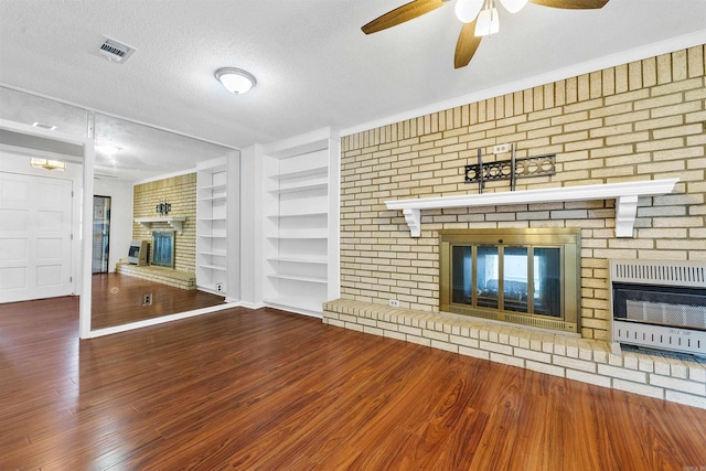 6500 W 12th St, Little Rock, AR 72204 - unfurnished living room with a brick fireplace, heating unit, built in features, ceiling fan, and wood finished floors