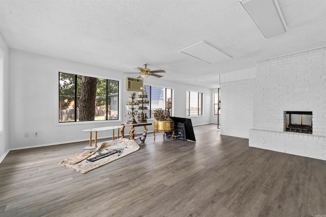 6500 W 12th St, Little Rock, AR 72204 - unfurnished living room featuring a textured ceiling, attic access, wood finished floors, baseboards, and an AC wall unit