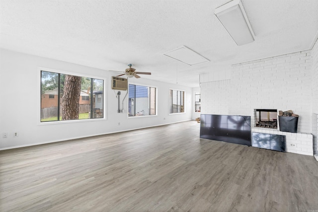 6500 W 12th St, Little Rock, AR 72204 - unfurnished living room with attic access, wood finished floors, a textured ceiling, a ceiling fan, and an AC wall unit