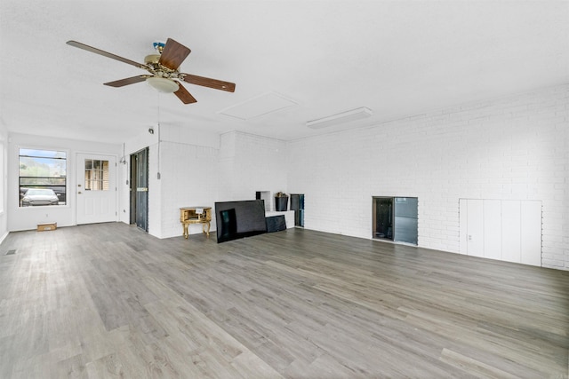6500 W 12th St, Little Rock, AR 72204 - unfurnished living room with a ceiling fan, wood finished floors, brick wall, and attic access