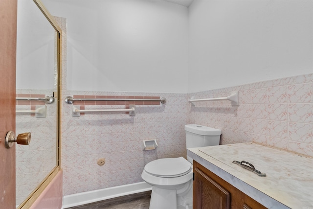 6500 W 12th St, Little Rock, AR 72204 - full bathroom with vanity, wainscoting, toilet, wood finished floors, and tile walls
