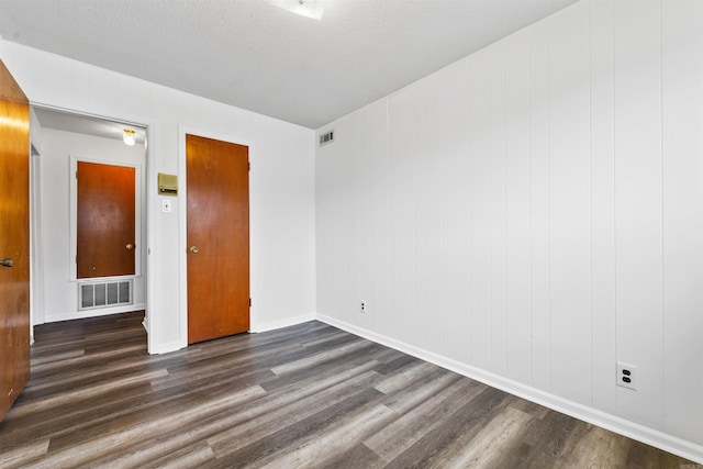 6500 W 12th St, Little Rock, AR 72204 - spare room featuring dark wood-style floors, baseboards, and a textured ceiling