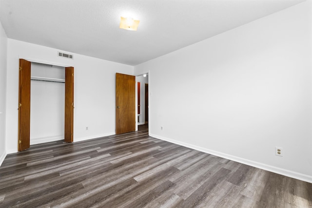 6500 W 12th St, Little Rock, AR 72204 - unfurnished bedroom with dark wood-style flooring, baseboards, and a closet