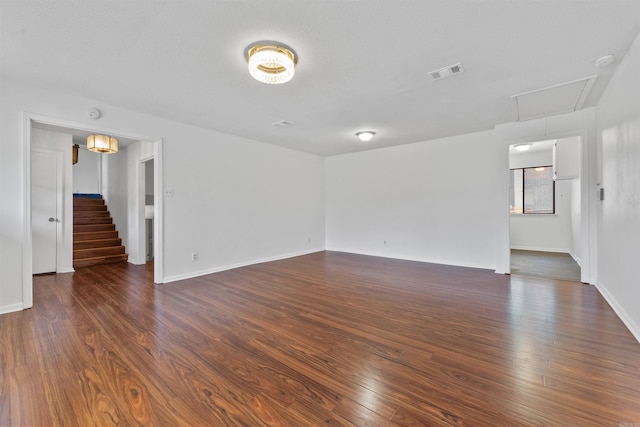 6500 W 12th St, Little Rock, AR 72204 - spare room featuring attic access, dark wood-type flooring, stairway, and baseboards