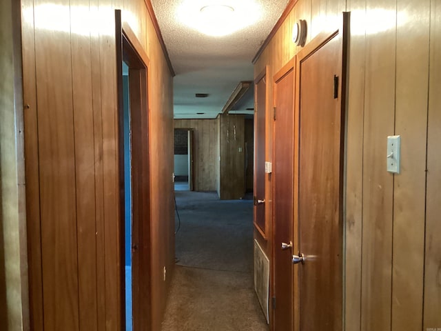 228 Nevada 66 W, Prescott, AR 71857 - hallway featuring dark colored carpet, a textured ceiling, and wooden walls