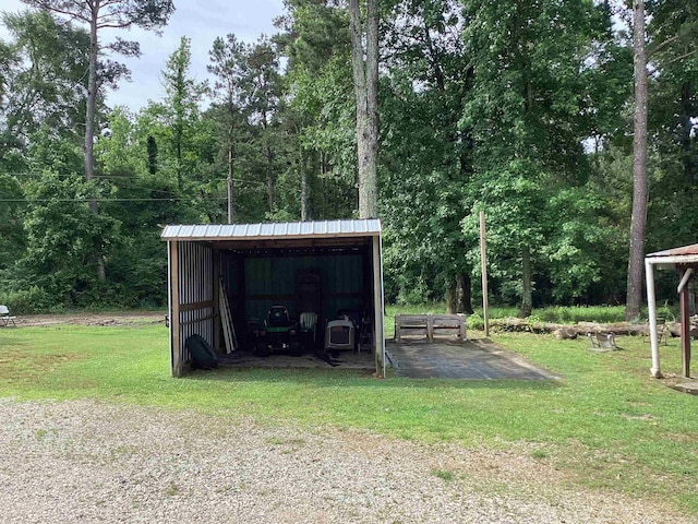 228 Nevada 66 W, Prescott, AR 71857 - view of pole building with a lawn, a carport, and a forest view