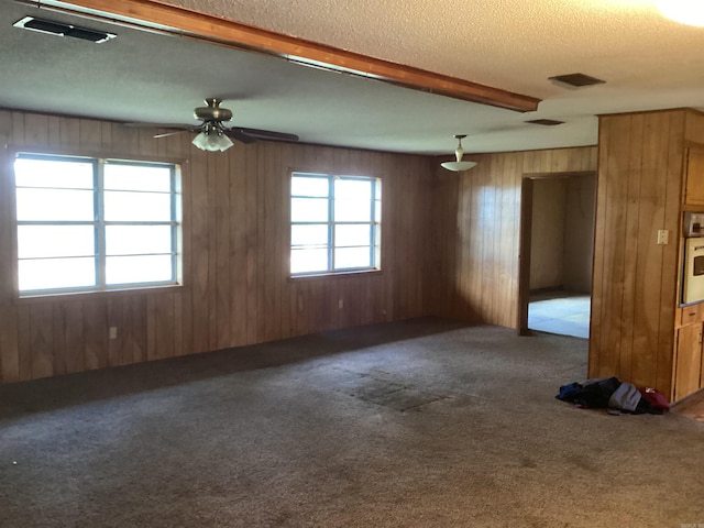 228 Nevada 66 W, Prescott, AR 71857 - carpeted empty room with wood walls, a textured ceiling, and a ceiling fan