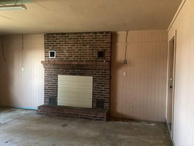 228 Nevada 66 W, Prescott, AR 71857 - unfurnished living room with a fireplace, unfinished concrete flooring, and wood walls