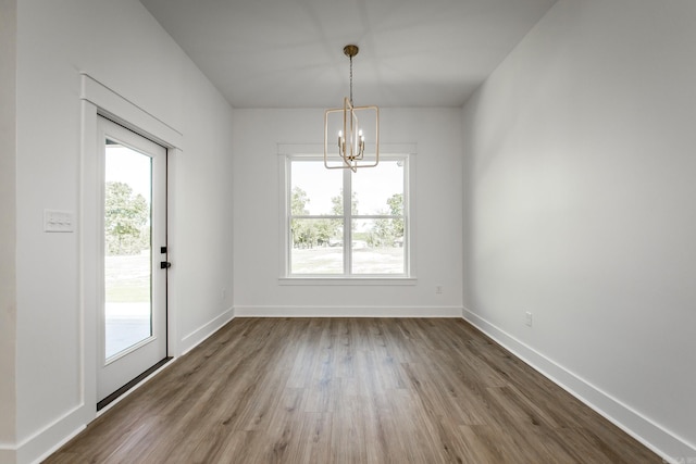 57 Republican Loop, Greenbrier, AR 72058 - unfurnished dining area featuring a chandelier, plenty of natural light, wood finished floors, and baseboards