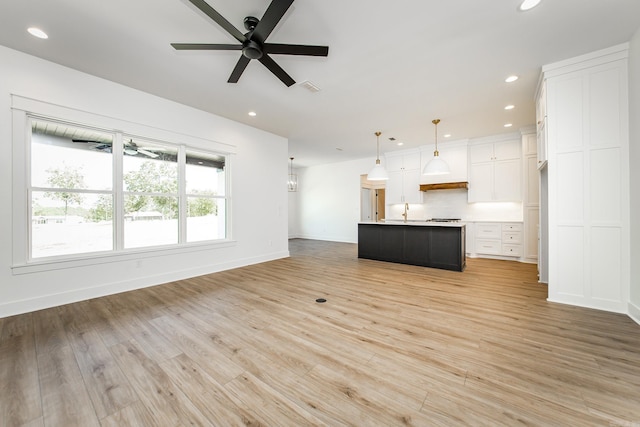 57 Republican Loop, Greenbrier, AR 72058 - unfurnished living room featuring a ceiling fan, recessed lighting, light wood-type flooring, baseboards, and a sink