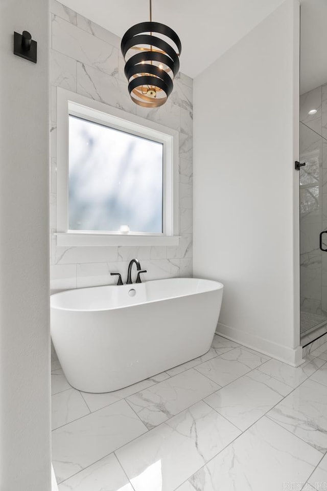 2505 Collins Dr, Conway, AR 72058 - full bath with marble look tiles, a freestanding tub, a marble finish shower, and baseboards
