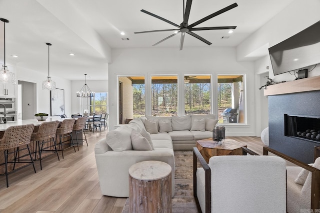 2505 Collins Dr, Conway, AR 72058 - living area featuring a ceiling fan, a fireplace, recessed lighting, light wood-style flooring, and a chandelier