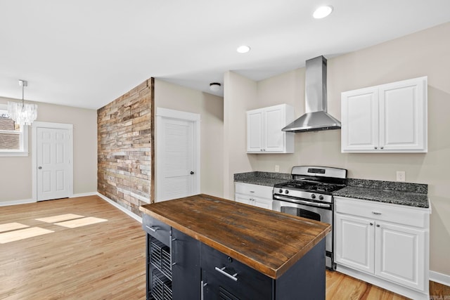 212 Barton St, Little Rock, AR 72205 - kitchen featuring gas range, wall chimney exhaust hood, butcher block counters, white cabinets, and light wood-type flooring