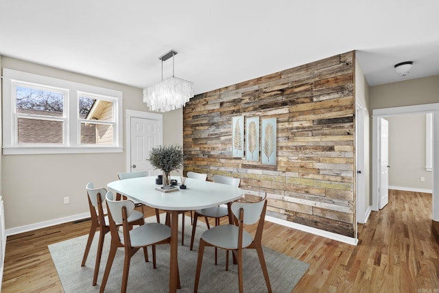 212 Barton St, Little Rock, AR 72205 - dining space with baseboards, wood finished floors, a chandelier, and wood walls