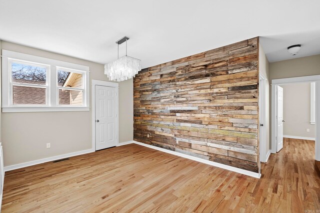 212 Barton St, Little Rock, AR 72205 - unfurnished dining area featuring a chandelier, light wood-type flooring, baseboards, and wood walls