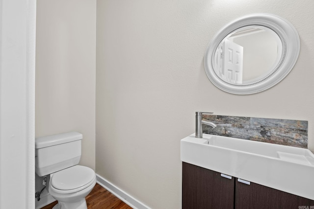 212 Barton St, Little Rock, AR 72205 - half bathroom featuring toilet, baseboards, wood finished floors, and vanity