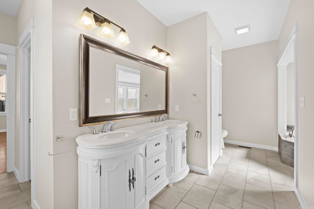 212 Barton St, Little Rock, AR 72205 - bathroom with double vanity, baseboards, toilet, and healthy amount of natural light