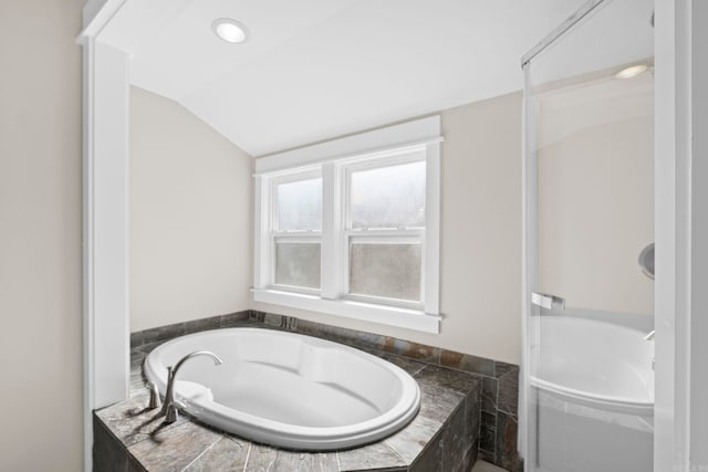 212 Barton St, Little Rock, AR 72205 - bathroom with a relaxing tiled tub and lofted ceiling