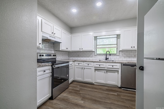1716 Walnut St, Arkadelphia, AR 71923 - kitchen with appliances with stainless steel finishes, a sink, under cabinet range hood, recessed lighting, and white cabinets