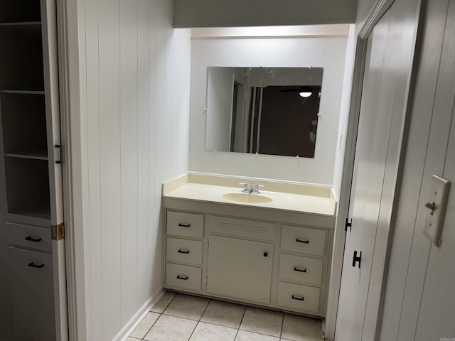 bathroom with vanity, tile patterned flooring, and wood walls