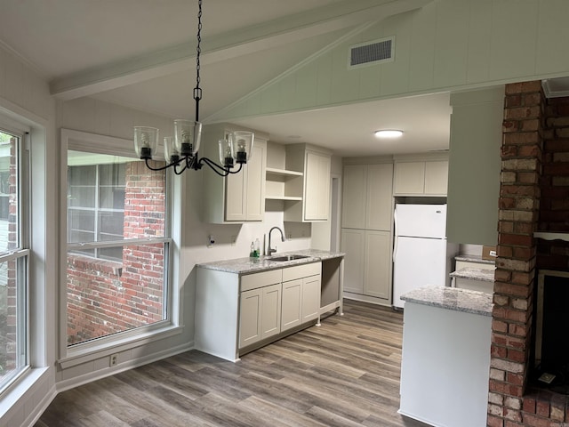 kitchen featuring freestanding refrigerator, a sink, open shelves, and plenty of natural light