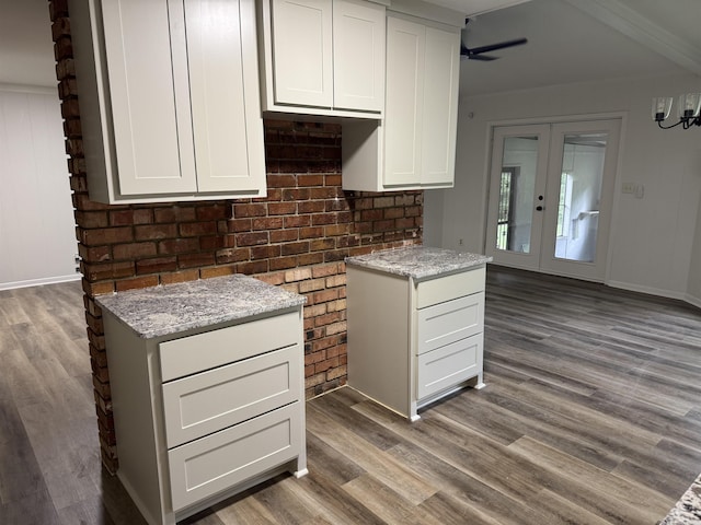 kitchen featuring wood finished floors, light stone counters, white cabinets, french doors, and a ceiling fan