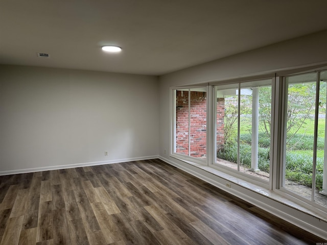 empty room with baseboards, dark wood-style flooring, and recessed lighting