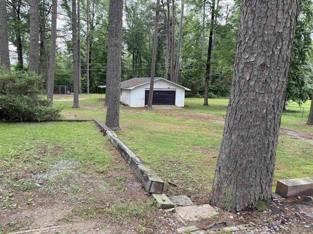 view of grassy yard with a garage and an outdoor structure