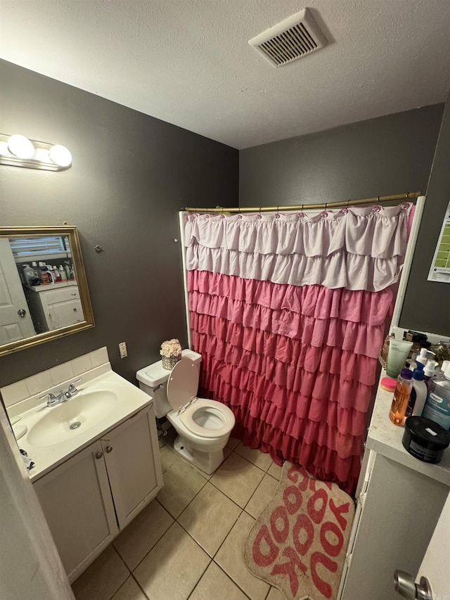 full bathroom with toilet, vanity, tile patterned floors, a textured ceiling, and curtained shower