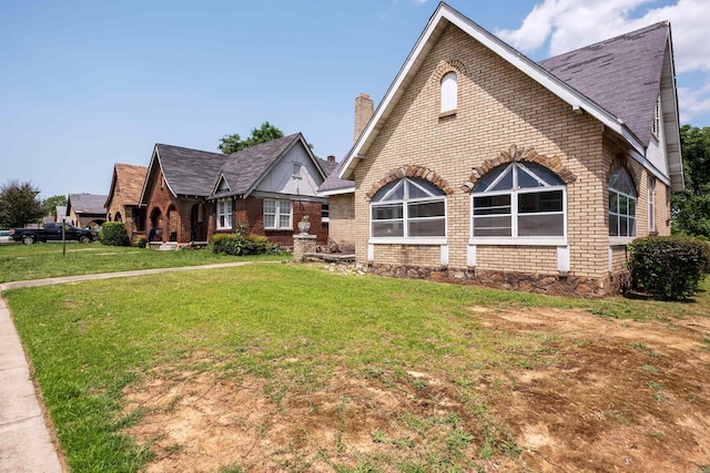 2815 Broadway St, Little Rock, AR 72206 - tudor house featuring brick siding, a chimney, a front lawn, and a shingled roof
