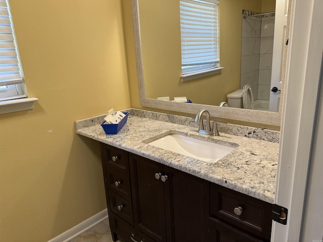 bathroom with vanity, toilet, baseboards, and shower / bath combination