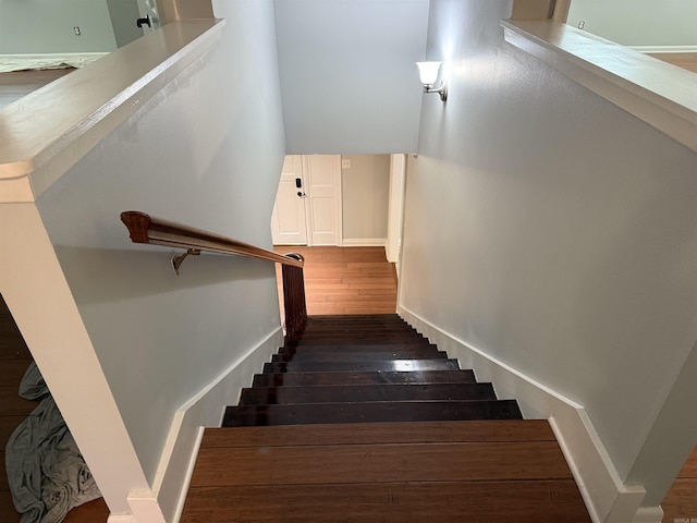 staircase with hardwood / wood-style floors and baseboards