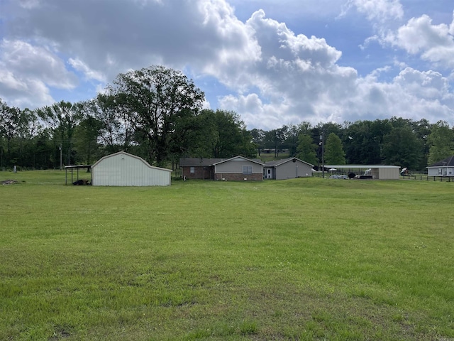 6873 Brazil Rd, Benton, AR 72019 - view of green lawn with a pole building, an outbuilding, and view of scattered trees