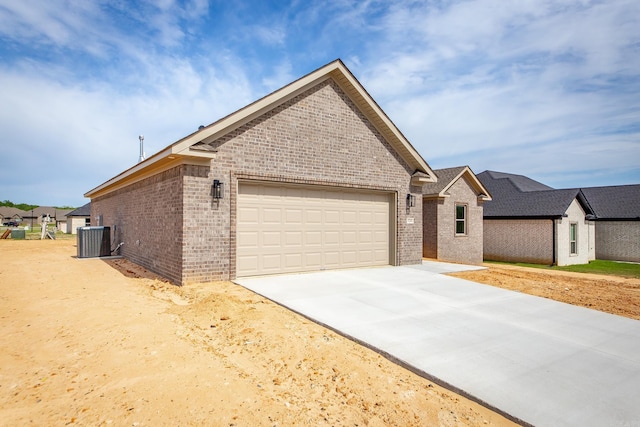 5201 Canter Ln, Jacksonville, AR 72076 - view of front of property featuring brick siding, central AC, a garage, and concrete driveway