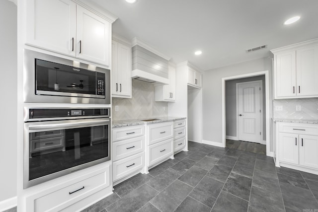 5201 Canter Ln, Jacksonville, AR 72076 - kitchen with oven, baseboards, decorative backsplash, white cabinets, and light stone countertops