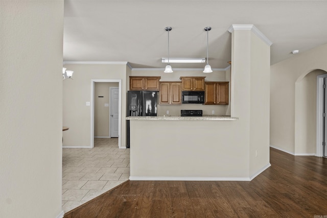 4114 Valles Rd, North Little Rock, AR 72118 - kitchen with black appliances, arched walkways, brown cabinets, decorative light fixtures, and baseboards