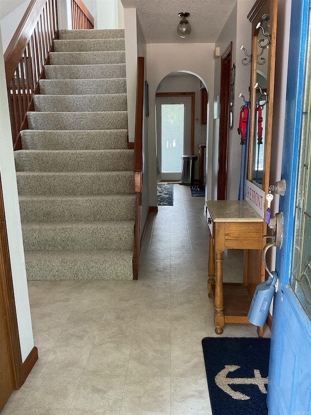 235 Sylvan Dr, Greers Ferry, AR 72067 - foyer featuring arched walkways, stairs, and a textured ceiling